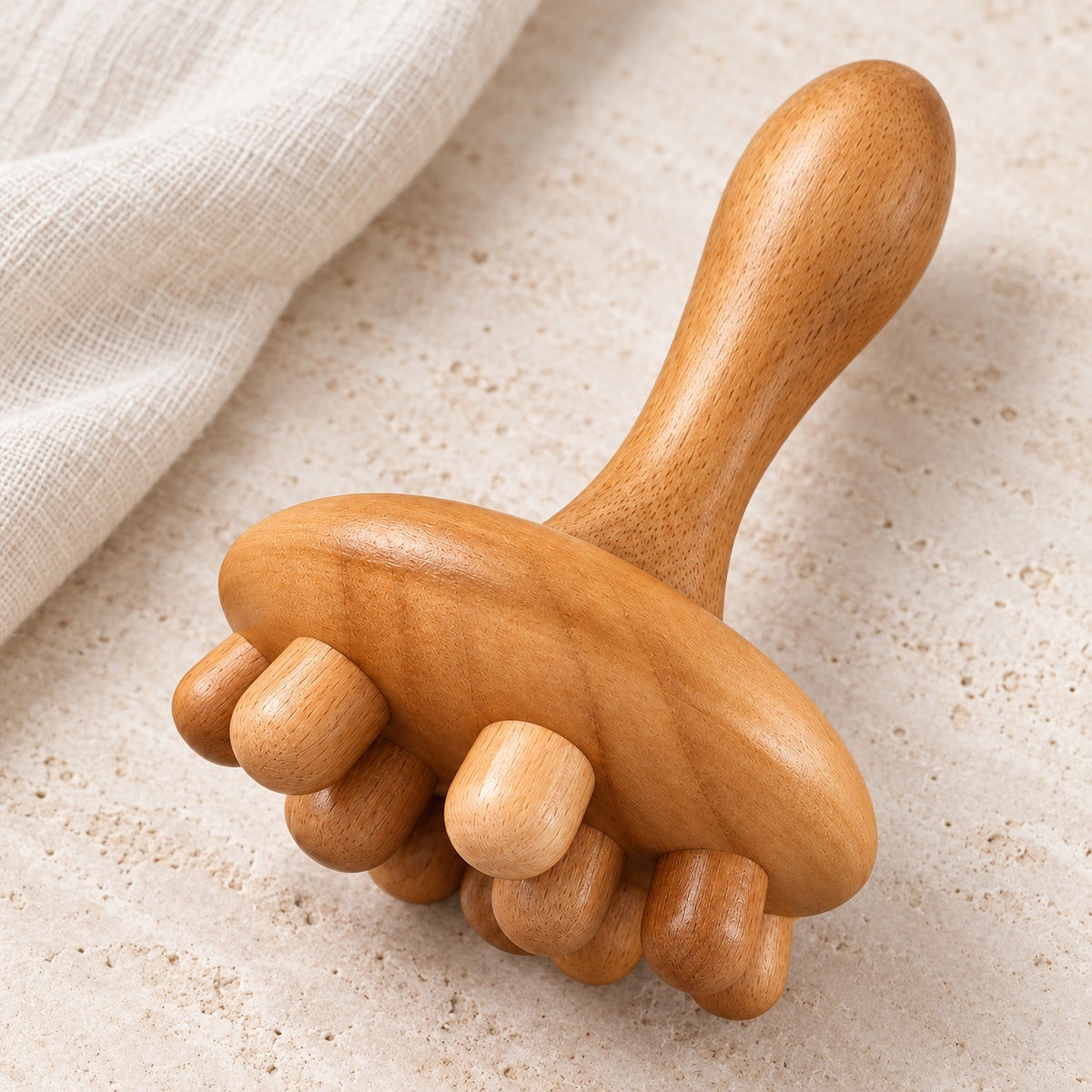 Masseur champignon en bois présenté sur fond clair avec du lin.