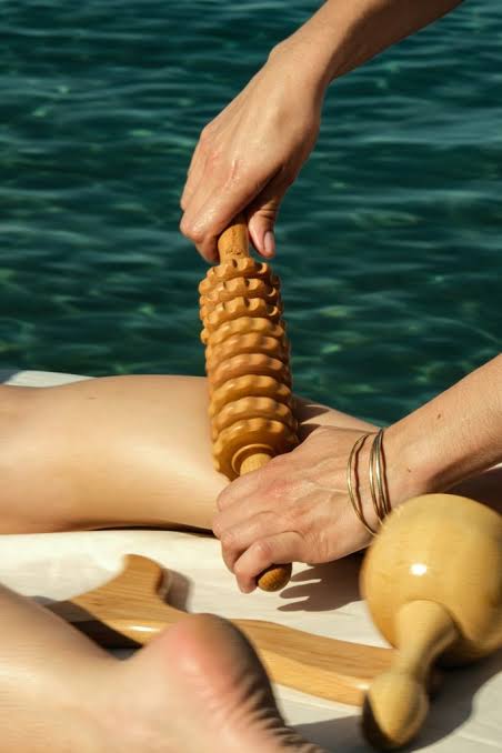 Rouleau à disques utilisé pour un massage des jambes en extérieur.