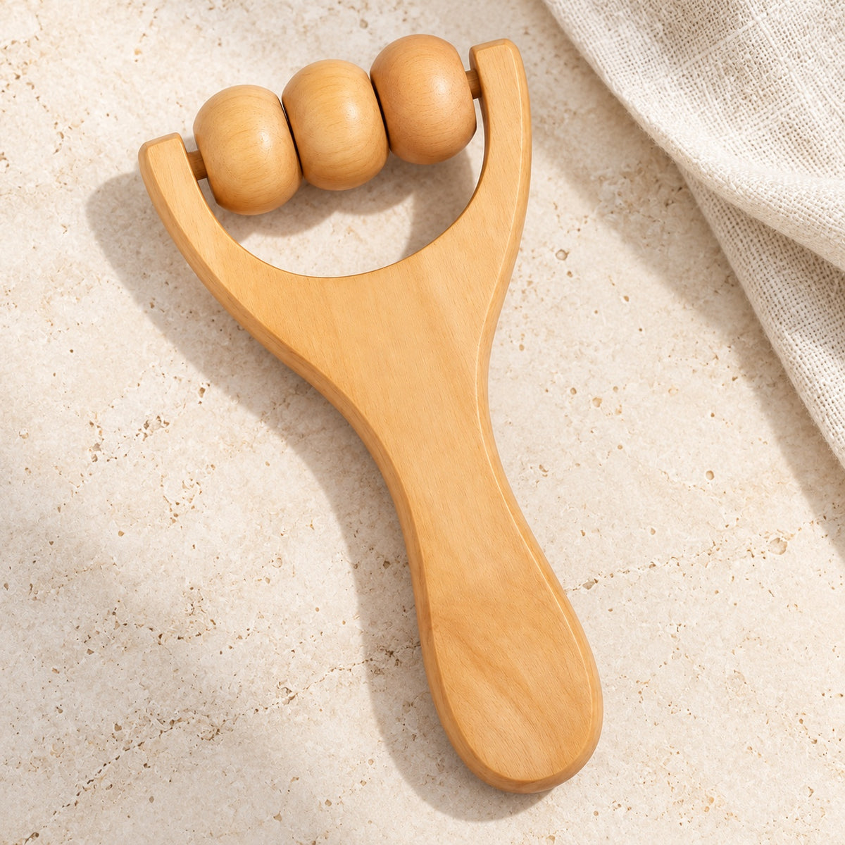 Petit rouleau K en bois sur fond clair avec du lin.